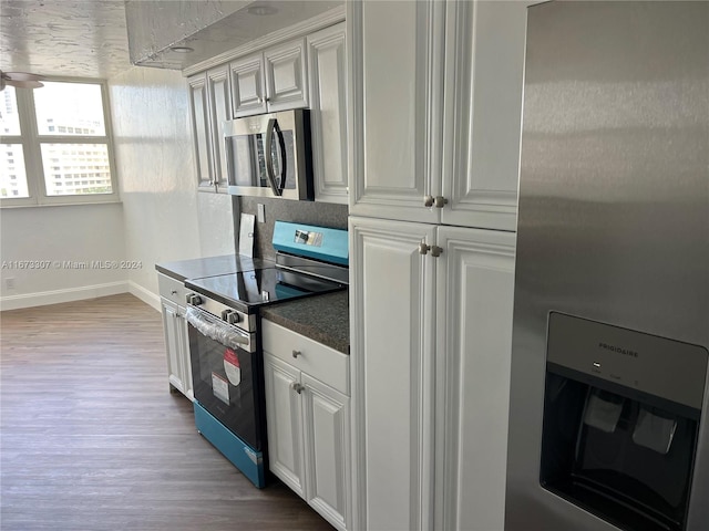 kitchen featuring appliances with stainless steel finishes, white cabinetry, and hardwood / wood-style floors