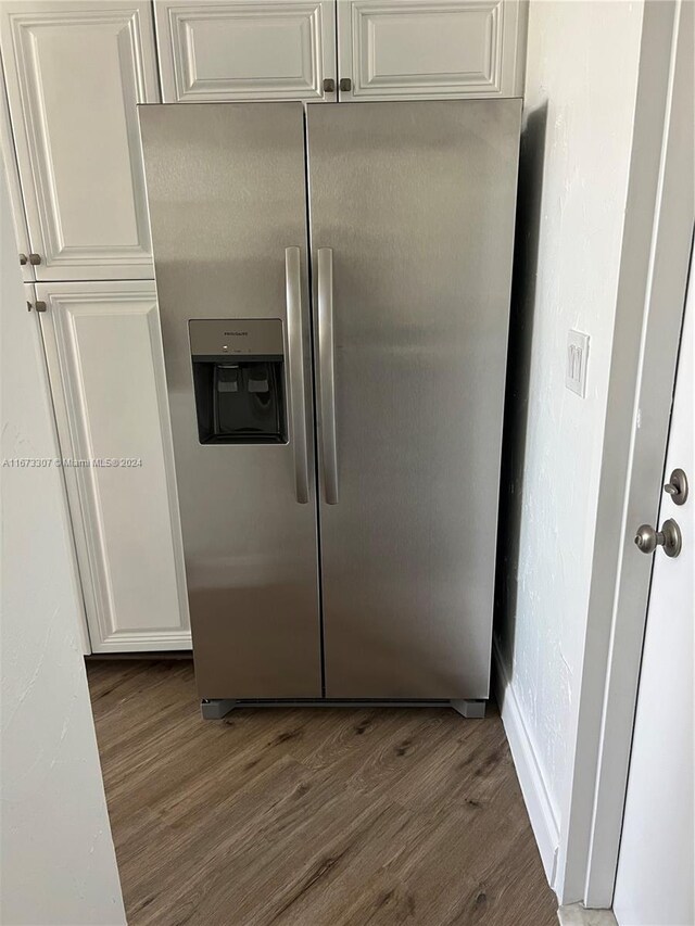 100 Golden Isles Dr Unit 605, Hallandale Beach, FL 33009 - details featuring dark wood-type flooring, white cabinetry, and stainless steel refrigerator with ice dispenser