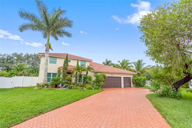 mediterranean / spanish house featuring a front yard and a garage