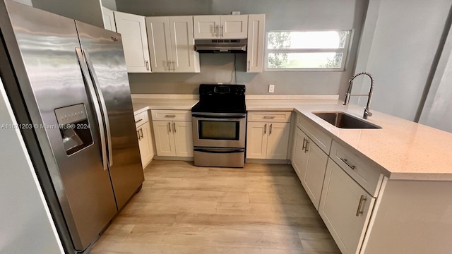 kitchen with white cabinets, light stone counters, appliances with stainless steel finishes, light wood-type flooring, and sink