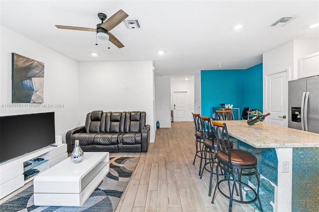 living room with light hardwood / wood-style floors and ceiling fan