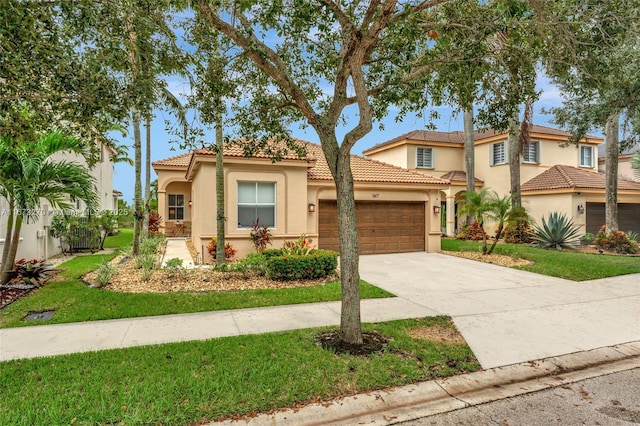 mediterranean / spanish house with a garage and a front lawn