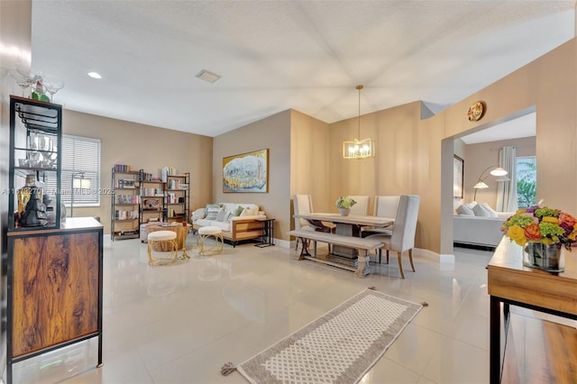 interior space featuring light tile patterned flooring, plenty of natural light, and a textured ceiling