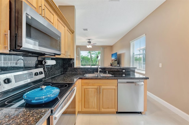 kitchen with sink, decorative backsplash, light tile patterned floors, and stainless steel appliances