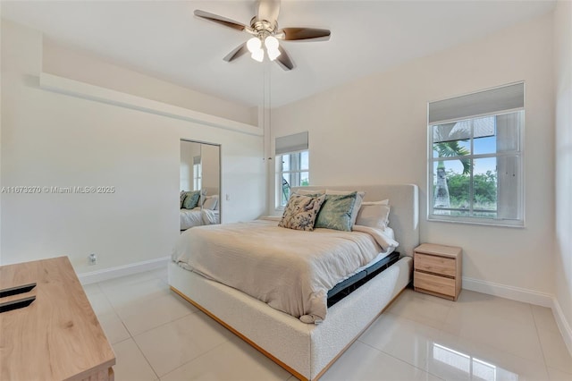 bedroom featuring a closet, light tile patterned floors, and ceiling fan