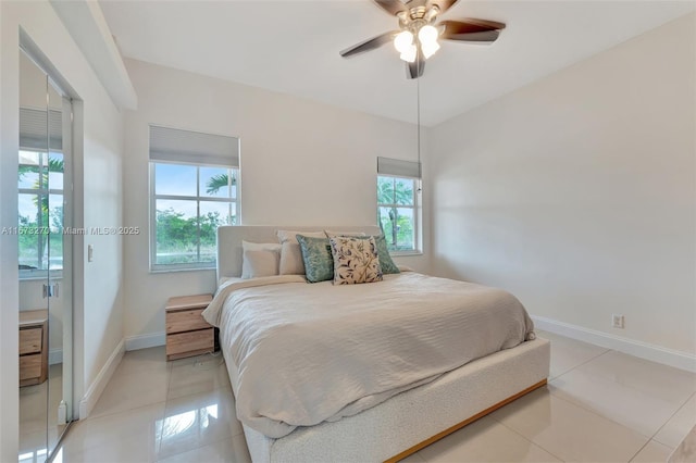 bedroom with ceiling fan and light tile patterned floors