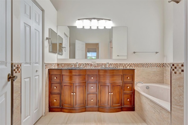 bathroom with a relaxing tiled tub, tile patterned floors, and vanity