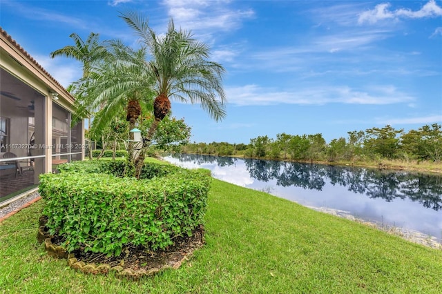 view of yard with ceiling fan and a water view