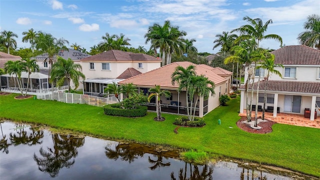 rear view of house with a lawn and a water view