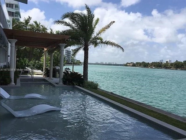 view of swimming pool featuring a water view and a pergola