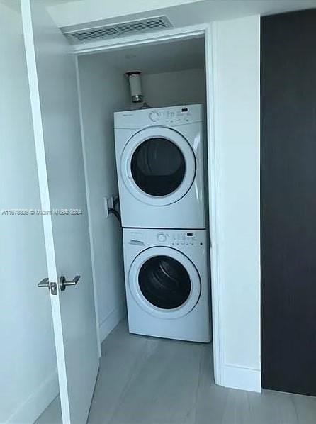 laundry area with stacked washer and clothes dryer