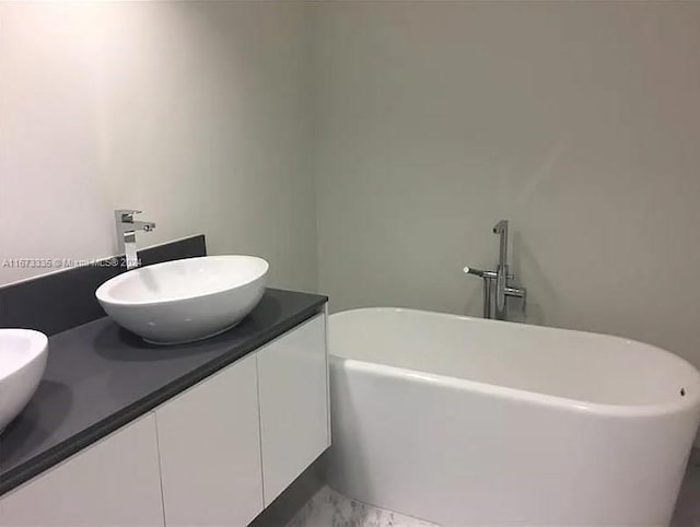 bathroom featuring a washtub and vanity