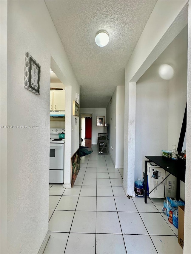 hallway featuring light tile patterned floors and a textured ceiling