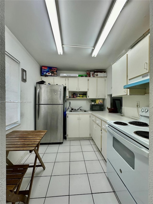 kitchen featuring electric stove, freestanding refrigerator, light countertops, under cabinet range hood, and a sink