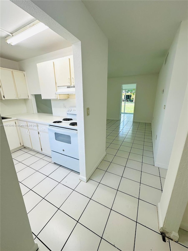 505 NW 177th St Unit 139, Miami Gardens, FL 33169 - kitchen featuring white range with electric stovetop, under cabinet range hood, light tile patterned flooring, light countertops, and white cabinets