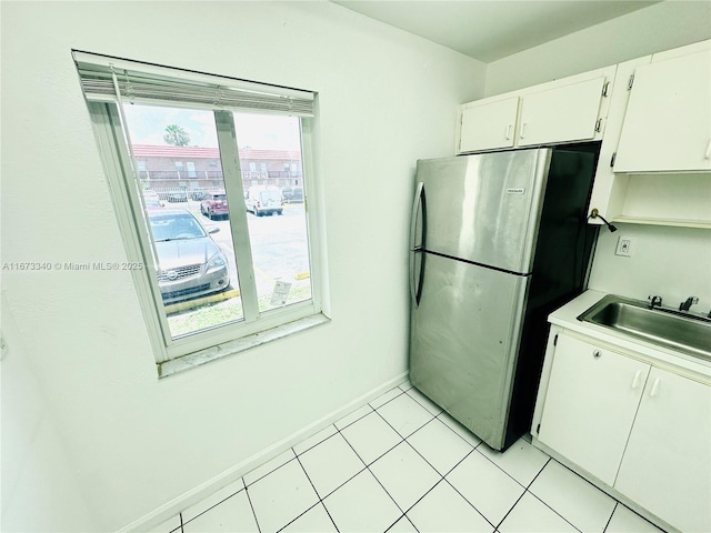 505 NW 177th St Unit 139, Miami Gardens, FL 33169 - kitchen with freestanding refrigerator, a sink, white cabinetry, light countertops, and baseboards
