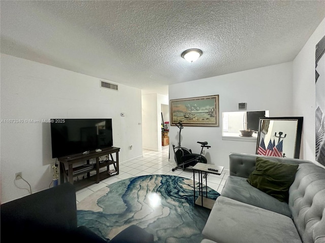 tiled living room featuring visible vents and a textured ceiling