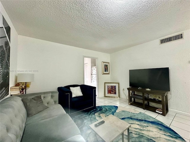 tiled living room featuring visible vents and a textured ceiling