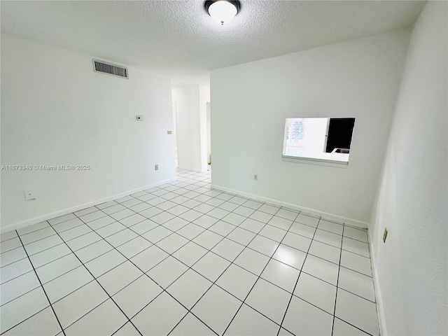 505 NW 177th St Unit 139, Miami Gardens, FL 33169 - spare room featuring a textured ceiling, baseboards, and light tile patterned floors