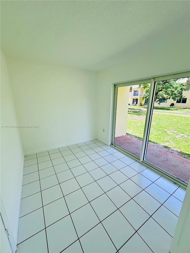 505 NW 177th St Unit 139, Miami Gardens, FL 33169 - empty room featuring light tile patterned floors, a textured ceiling, and baseboards