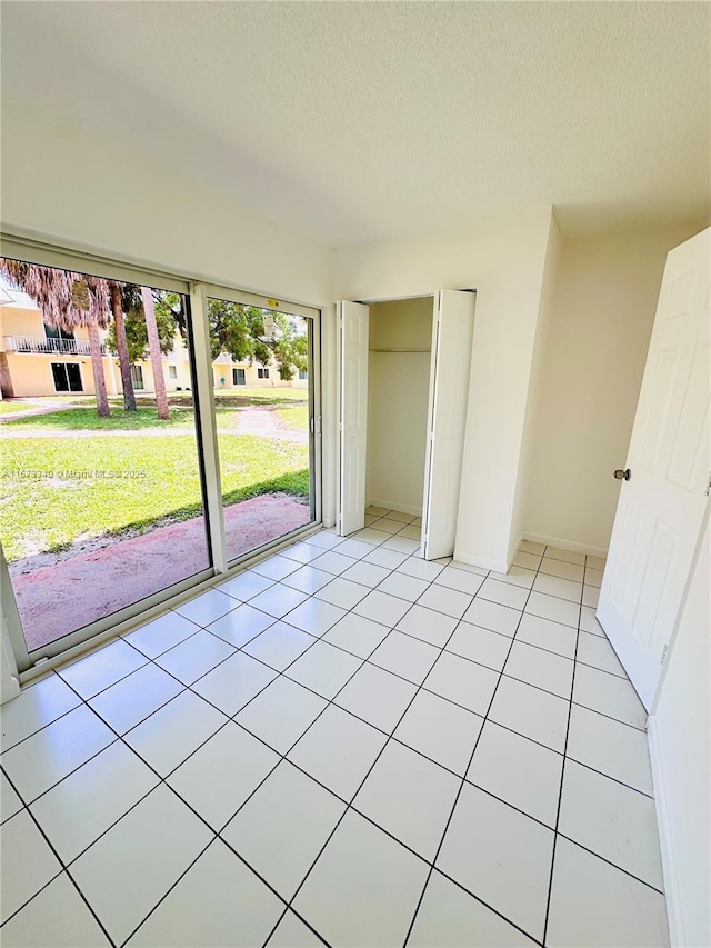 505 NW 177th St Unit 139, Miami Gardens, FL 33169 - unfurnished bedroom with a textured ceiling, light tile patterned floors, and baseboards