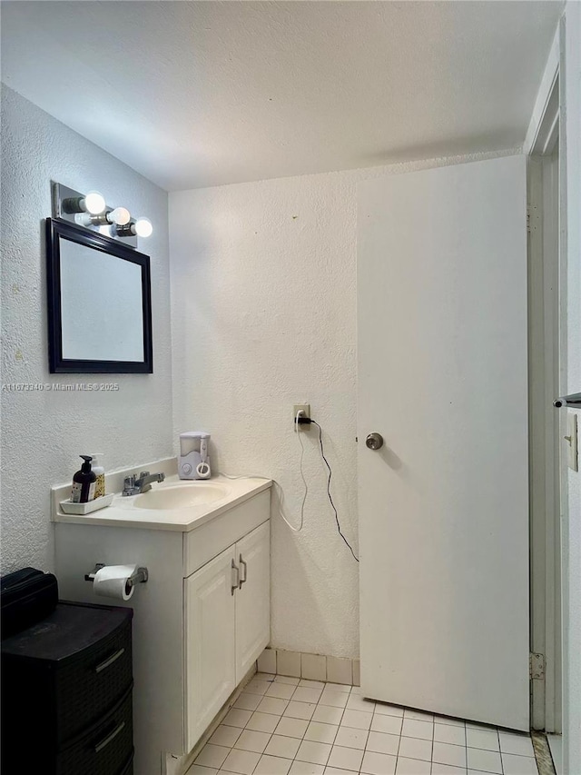 bathroom featuring a textured wall, vanity, and tile patterned floors