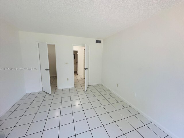 505 NW 177th St Unit 139, Miami Gardens, FL 33169 - spare room with a textured ceiling and light tile patterned floors