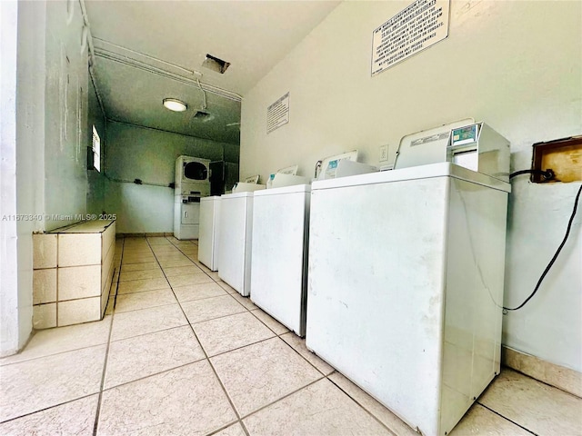 shared laundry area with washing machine and dryer and light tile patterned floors