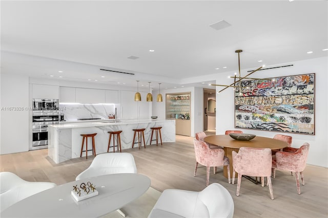 dining area featuring a notable chandelier and light hardwood / wood-style floors