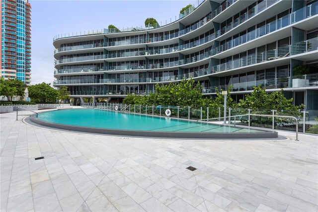 view of swimming pool with a hot tub