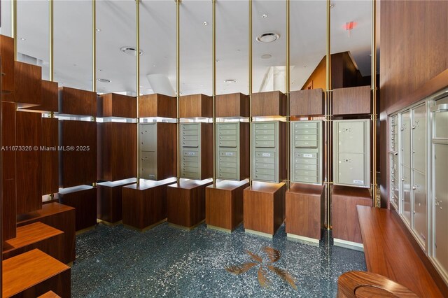 miscellaneous room featuring a mail area and a towering ceiling