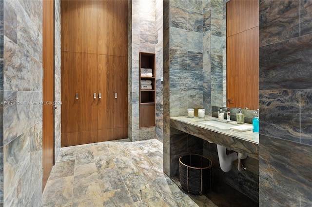 bathroom featuring sink and tile walls