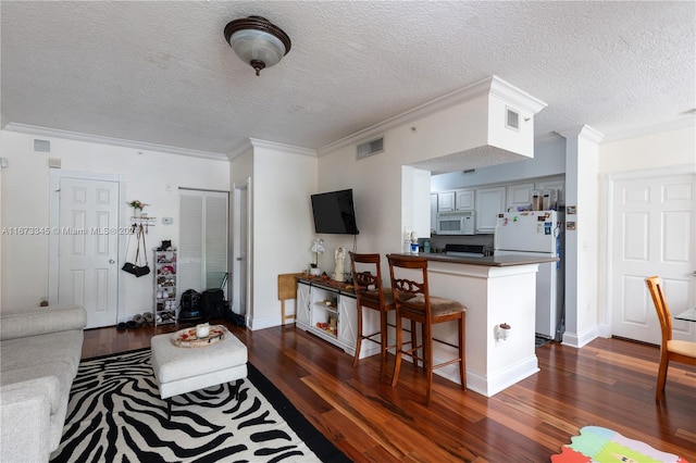 living room featuring a textured ceiling, dark hardwood / wood-style floors, and crown molding