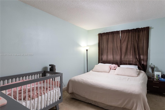 bedroom featuring light carpet and a textured ceiling