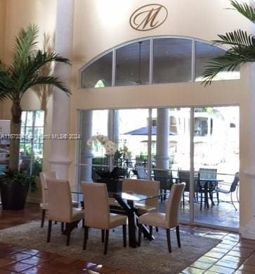 dining room with a healthy amount of sunlight and a towering ceiling