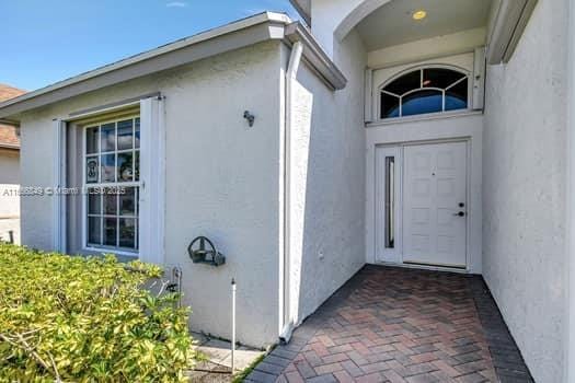 entrance to property featuring stucco siding