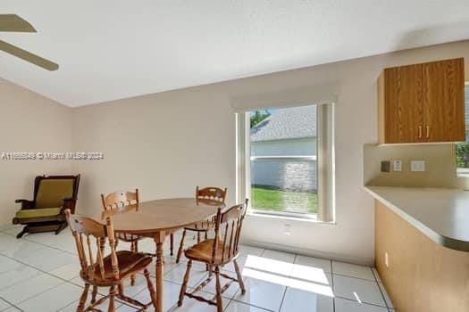 tiled dining room featuring ceiling fan