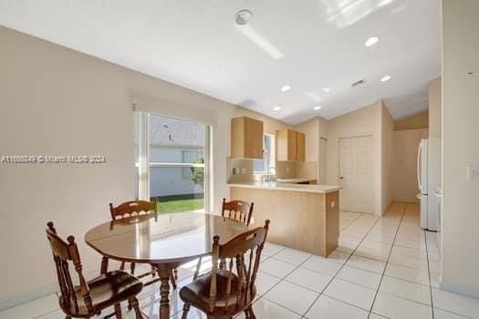 dining room featuring light tile patterned floors and lofted ceiling