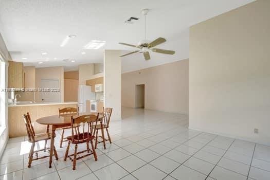 tiled dining space with ceiling fan