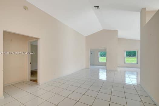 5127 Robino Cir, West Palm Beach, FL 33417 - spare room featuring light tile patterned floors and vaulted ceiling