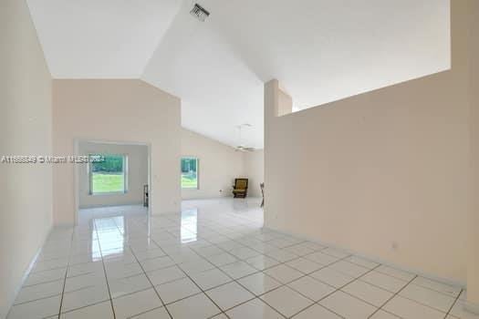 tiled spare room with lofted ceiling