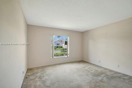 empty room featuring carpet and baseboards