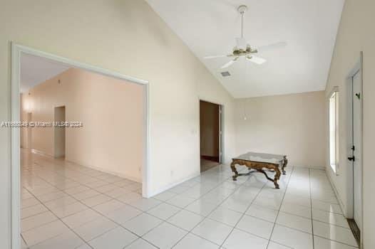 spare room with ceiling fan, light tile patterned floors, and high vaulted ceiling