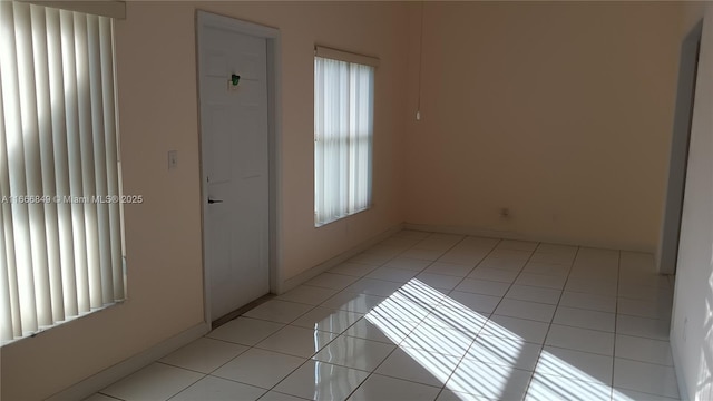 empty room featuring light tile patterned floors and baseboards