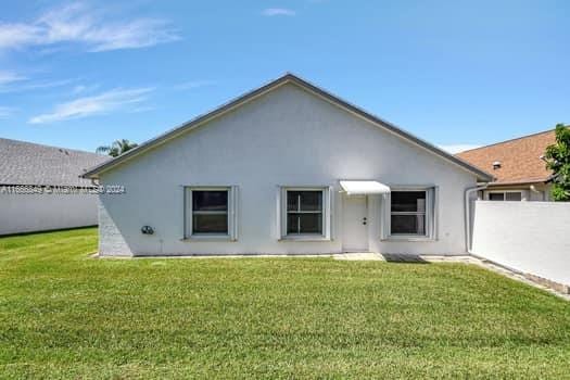 rear view of property with a lawn