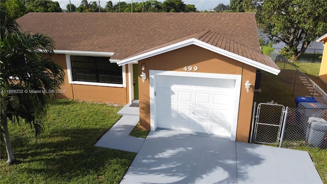 ranch-style house featuring a front yard and a garage