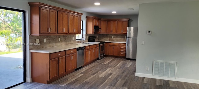 kitchen with appliances with stainless steel finishes, backsplash, dark hardwood / wood-style floors, and sink