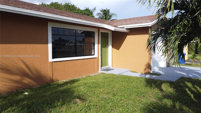 property entrance featuring a lawn