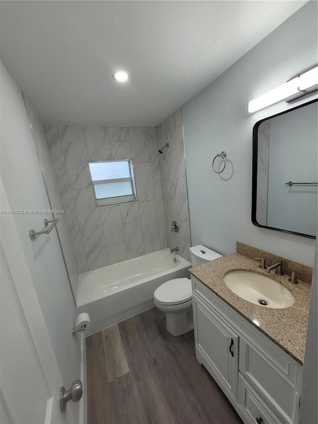 full bathroom with vanity, toilet, wood-type flooring, and tiled shower / bath combo