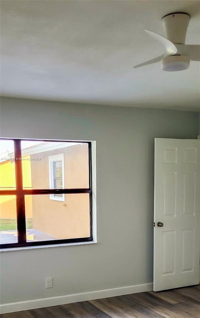 spare room featuring ceiling fan, a healthy amount of sunlight, and hardwood / wood-style flooring